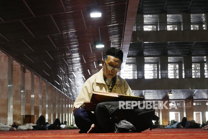  Seorang jamaah laki-laki sedang membaca ayat-ayat suci Alquran di Masjid Istiqlal Jakarta, Senin (6/6).(Republika/Darmawan)