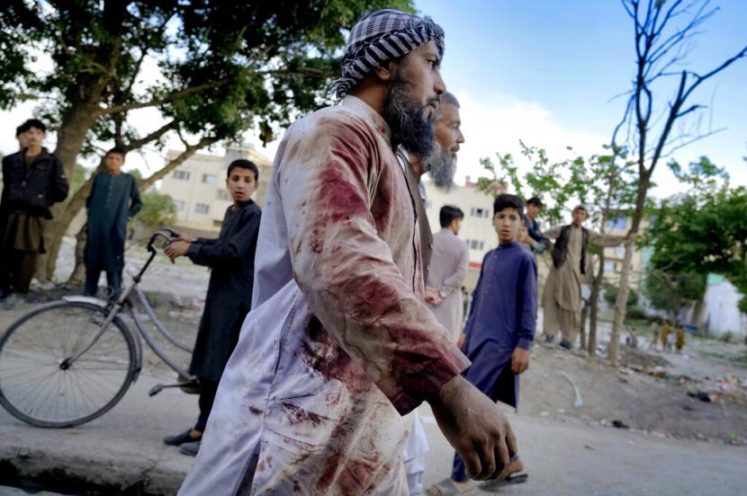Seorang jemaah Afghanistan yang berlumuran darah berjalan di sekitar masjid tempat ledakan terjadi, di Kabul, Afghanistan. Dalam sebulan terakhir, tiga pemimpin agama terkemuka menjadi sasaran di Kabul dan ada pembunuhan di kota-kota lain.
