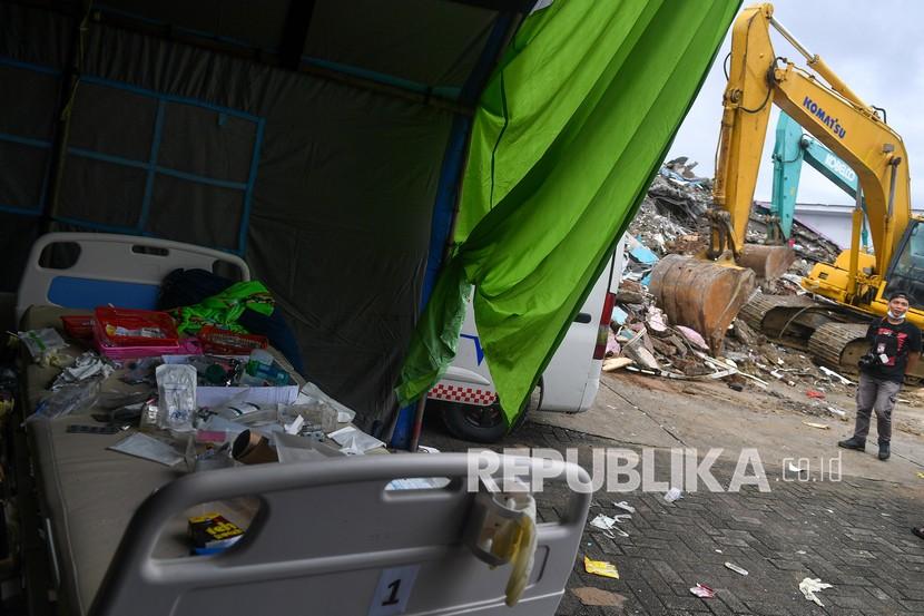 Seorang jurnalis melintas di sisa bangunan Rumah Sakit Mitra Manakarra yang roboh akibat gempa bumi magnitudo 6,2 di Mamuju, Sulawesi Barat, Sabtu (16/1/2021). 