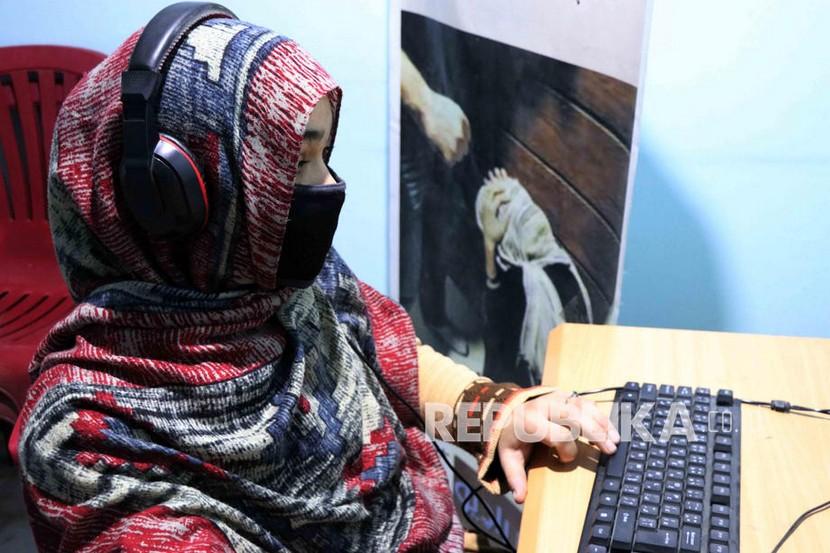 Seorang jurnalis wanita Afghanistan bekerja di stasiun radio Women in Kandahardi Kandahar. Industri media menjadi sektor yang paling terdampak sejak berkuasanya Taliban .