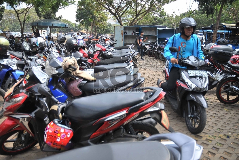 Seorang juru parkir mengarahkan pengendara saat parkir di kawasan IRTI MOnas, Jakarta Pusat, Selasa (26/5).