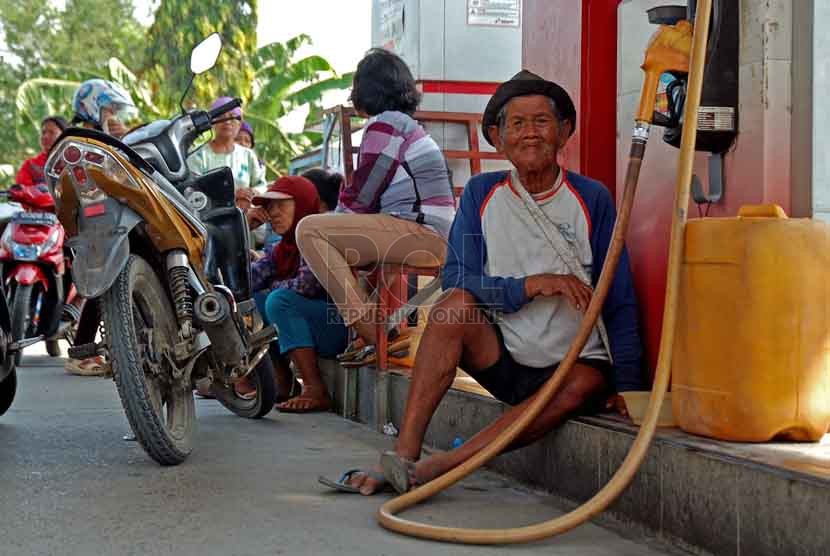 Seorang kakek menunggu jerigen nya untuk diisi BBM jenis premium di SPBU Anjatan, Indramayu, Selasa (26/8).(Republika/Raisan Al Farisi)