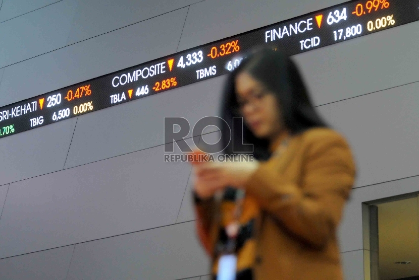 Seorang karyawan melintas didekat layar elektronik pergerakan Indeks harga saham gabungan (IHSG) di gedung Bursa Efek Indonesia, Jakarta, Jumat (11/9).