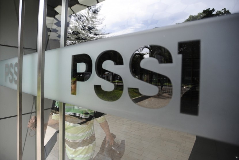  Seorang karyawan melintasi tulisan PSSI di Kantor PSSI Senayan, Jakarta, Jumat (26/2). 