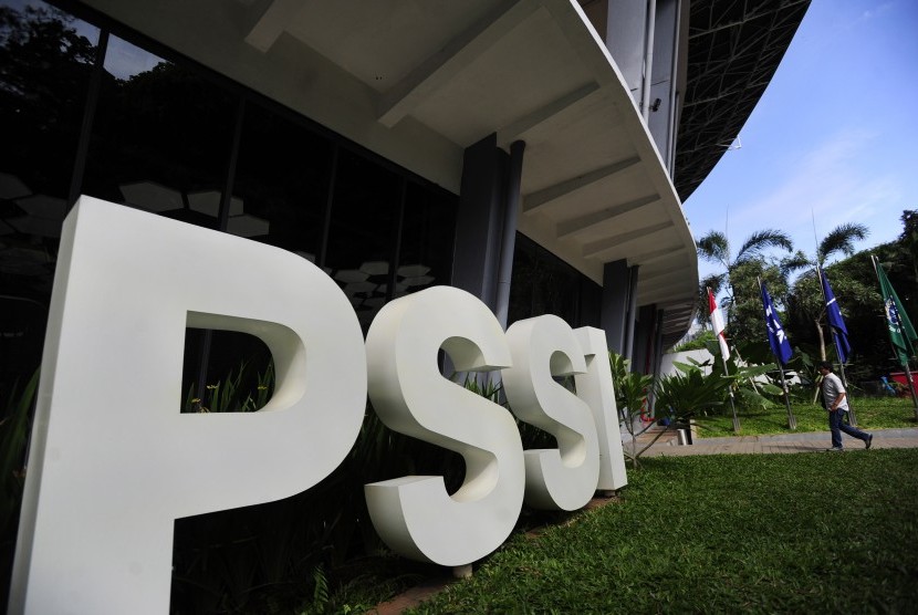 Seorang karyawan melintasi tulisan PSSI di Kantor PSSI Senayan, Jakarta, Jumat (26/2).