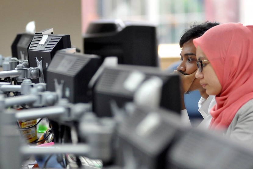 Seorang karyawan mengamati pergerakan saham di dealing room BRI, Jakarta, Senin (30/6).