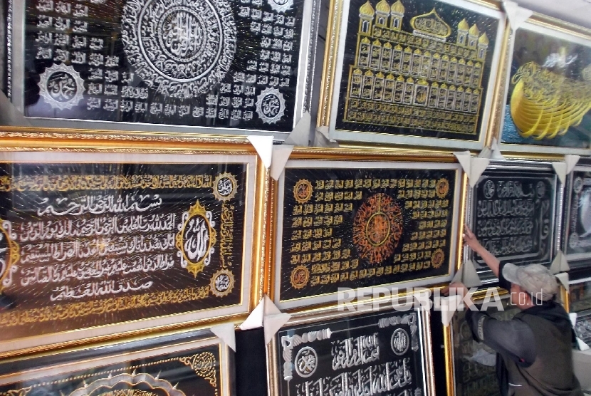 Seorang karyawan toko frame merapihkan display kaligrafi di tokonya di Jakarta, Senin (21/3).