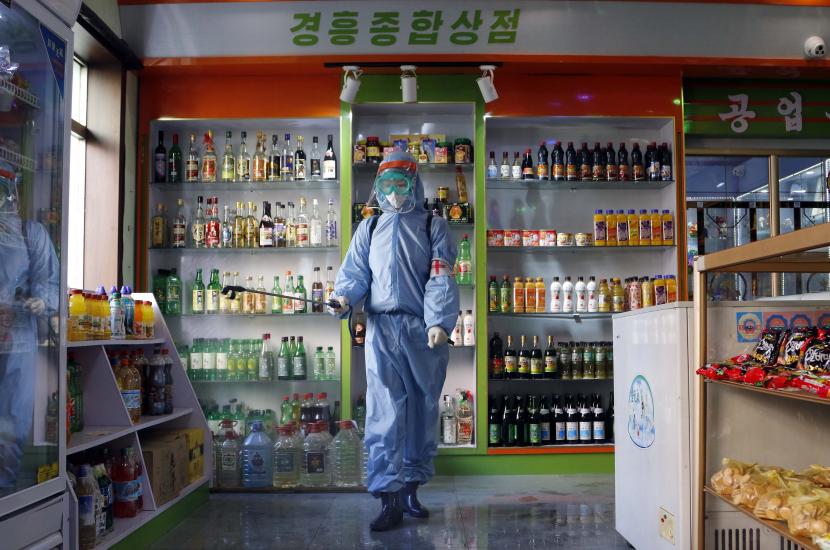 Seorang karyawan Toko Umum Bahan Makanan Kyonghung mendisinfeksi ruang pamer di Pyongyang, Korea Utara.