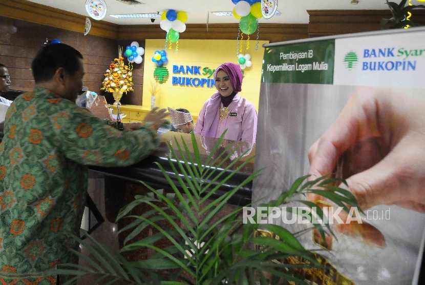 Seorang karyawati melayani nasabah di Banking Hall Bank Syariah Bukopin, Jakarta, Selasa (27/12). 