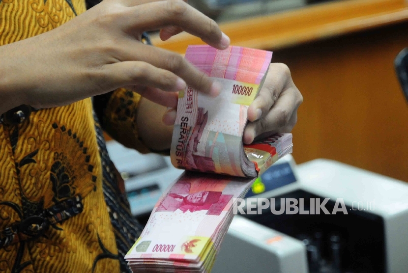 Seorang karyawati menghitung uang Rupiah pecahan seratus ribu disalah satu tempat penukaran uang di Jakarta Pusat, Senin (18/7).  (Republika/Agung Supriyanto)