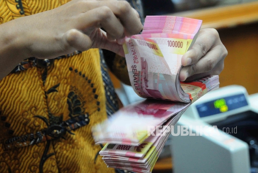 Seorang karyawati menghitung uang Rupiah pecahan seratus ribu disalah satu tempat penukaran uang di Jakarta Pusat, Senin (18/7).  (Republika/Agung Supriyanto)