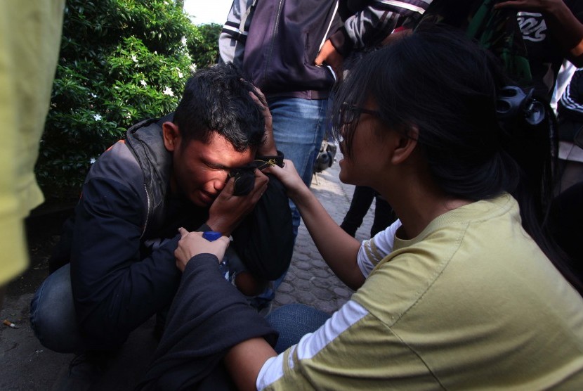 Seorang kerabat keluarga korban banjir bandang menangis di RS Bhayangkara Polda Sumut, Medan, Senin (16/5). 