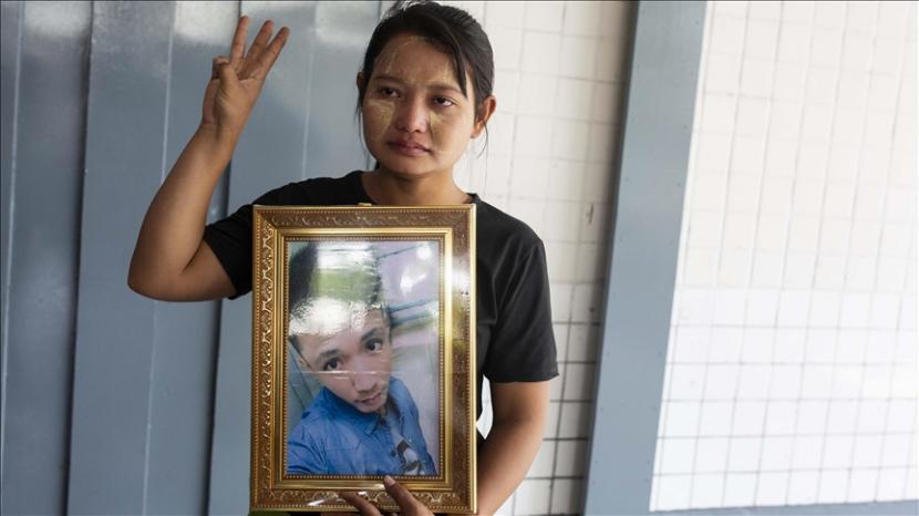 Seorang kerabat membawa foto korban tewas dalam demonstrasi menentang junta militer di Myanmar. 