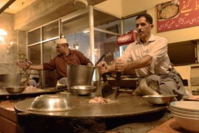 Seorang koki menyiapkan hidangan khas di Lahore  yang terbuat dari daging kambing.