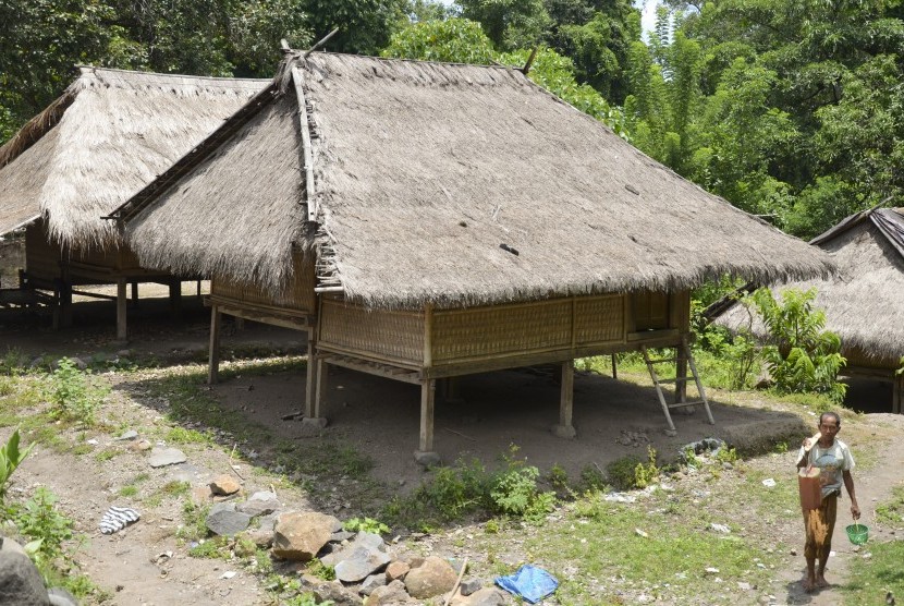 Seorang laki-laki melintas dekat bangunan rumah tradisional Bayan di Dusun Adat Sembagik, Desa Sukadana, Kecamatan Bayan, Tanjung, Lombok Utara, NTB, Minggu (12/3). 