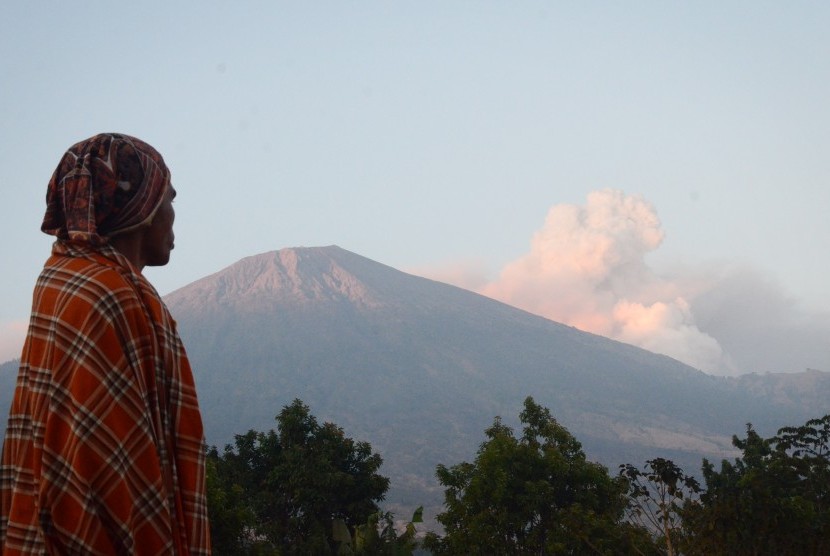 Seorang laki-laki memperhatikan semburan material vulkanik Gunung Barujari dari Desa Sembalun Lawang, Kecamatan Sembalun, Selong, Lombok Timur, NTB, Selasa (10/11). 