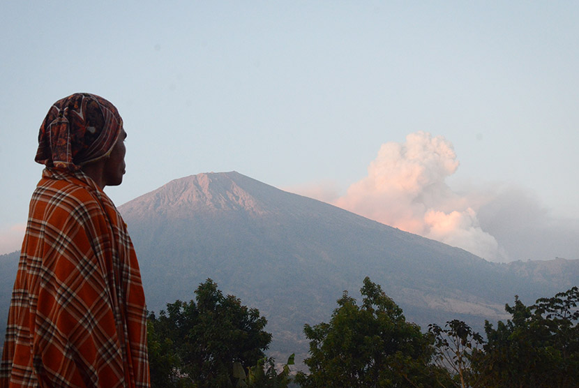 Seorang laki-laki memperhatikan semburan material vulkanik Gunung Barujari dari Desa Sembalun Lawang, Kecamatan Sembalun, Selong, Lombok Timur, NTB, Selasa (10/11).