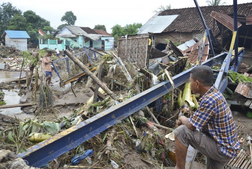 Seorang laki-laki mencari barangnya yang masih bisa dipakai pasca terjadi banjir bandang susulan di Kota Bima, NTB, Sabtu (24/12).