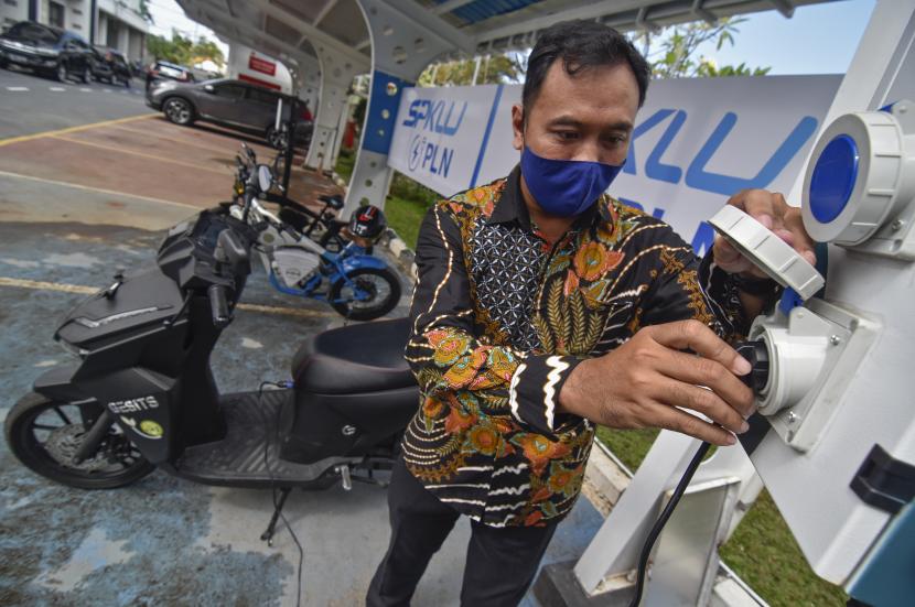 Seorang laki-laki mengisi daya sepeda motor listriknya di Stasiun Pengisian Kendaraan Listrik Umum (SPKLU) di Mataram, NTB, Jumat (19/3). Hingga bulan September 2021, Kementerian ESDM mencatat sudah terdapat 187 unit SPKLU yang beroperasi dan tersebar di 155 lokasi di seluruh Indonesia.