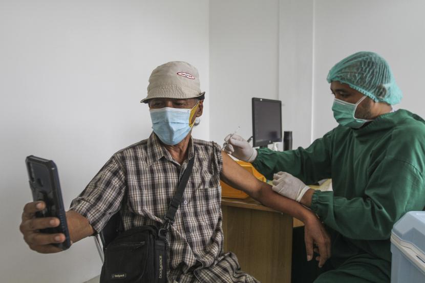 Seorang lansia melakukan swafoto saat vaksinasi lanjutan (booster) dengan jenis pfizer, (ilustrasi).