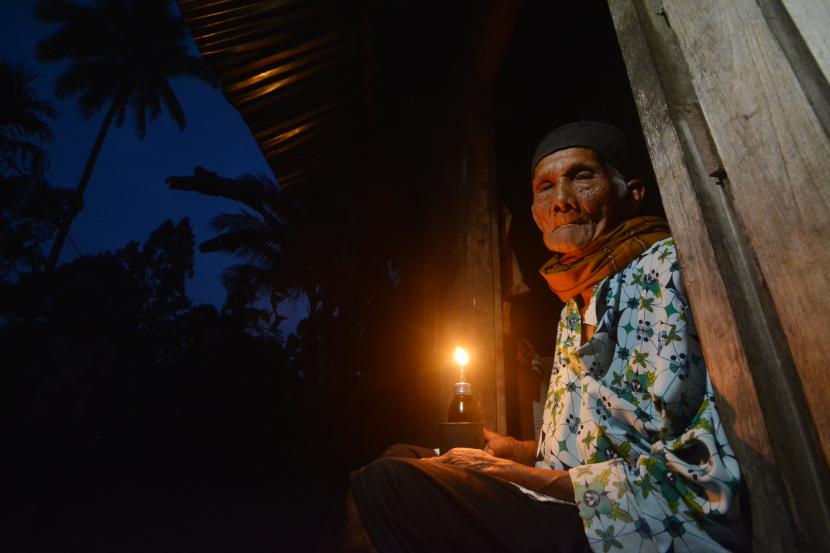 Seorang lansia, Yuliar (70) menggunakan lampu minyak di rumahnya di Korong Patamuan, Nagari Padang Alai, Kabupaten Padangpariaman, Sumatera Barat.
