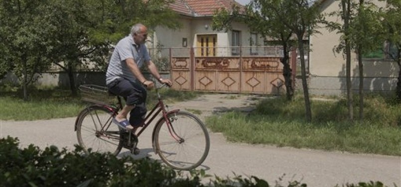 Seorang lelaki tua, dengan sepeda ontel, melintasi depan rumah tempat persembunyian Ratko Mladic si Jagal Balkan, di desa Lazarevo, Beograd, Serbia, Sabtu (28/5).
