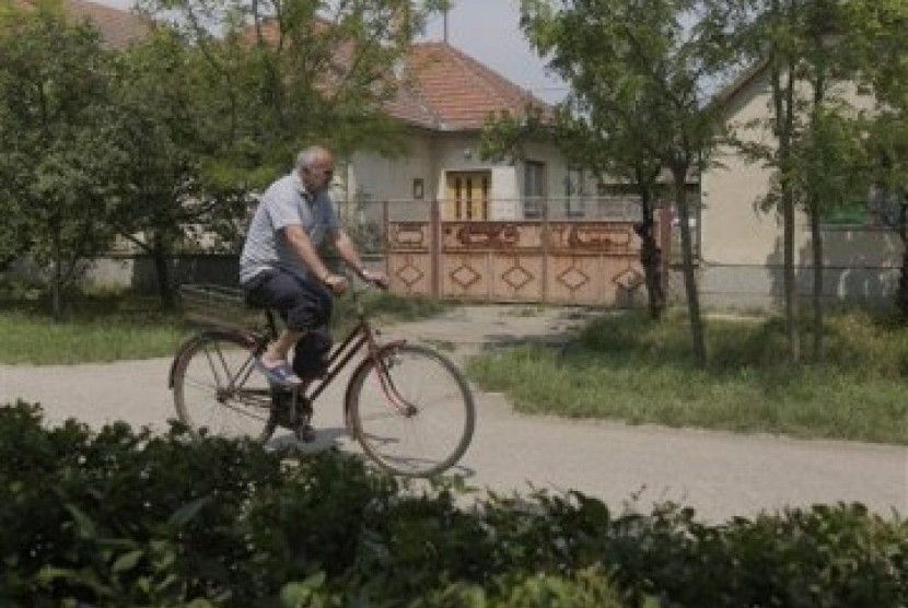 Seorang lelaki tua, dengan sepeda ontel, melintasi depan rumah tempat persembunyian Ratko Mladic si Jagal Balkan, di desa Lazarevo, Beograd, Serbia, Sabtu (28/5).