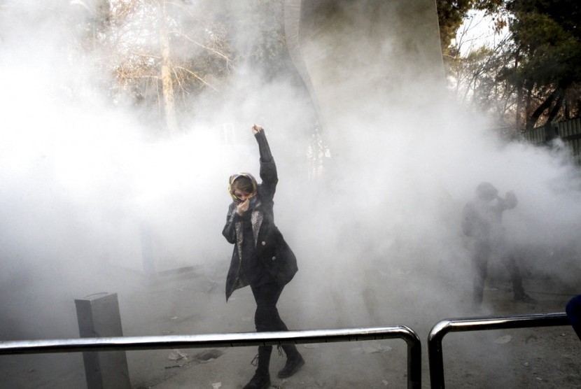 Seorang mahasiswa berdemonstrasi di depan Universitas Teheran, Teheran, Iran, Sabtu (30/12).