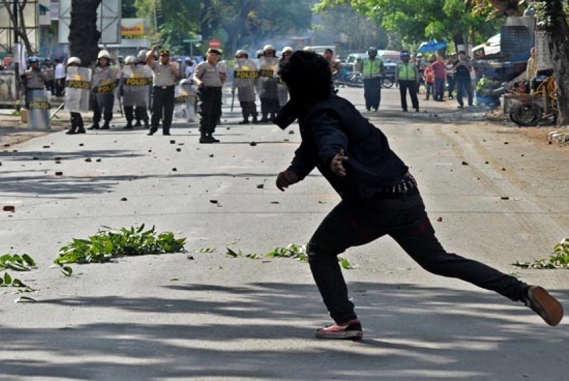  Seorang mahasiswa melempar batu saat terjadi bentrokan antara polisi dan mahasiswa di depan sekretariat Himpunanan Mahasiswa Islam (HMI) di Makassar, Sulsel, Senin (3/6).    (Antara/Sahrul Manda Tikupadang)