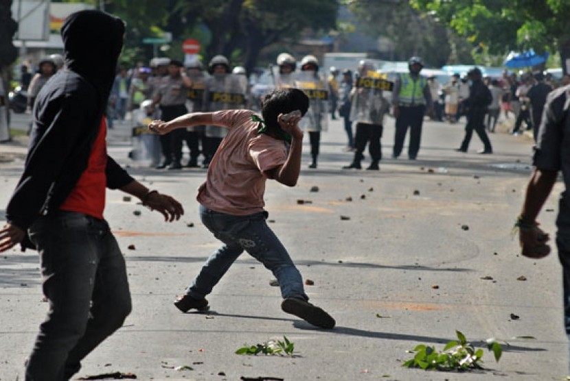 Seorang mahasiswa melempar batu saat terjadi bentrokan antara polisi dan mahasiswa di depan sekretariat Himpunanan Mahasiswa Islam (HMI) di Makassar, Sulsel, Senin (3/6).    (Antara/Sahrul Manda Tikupadang)