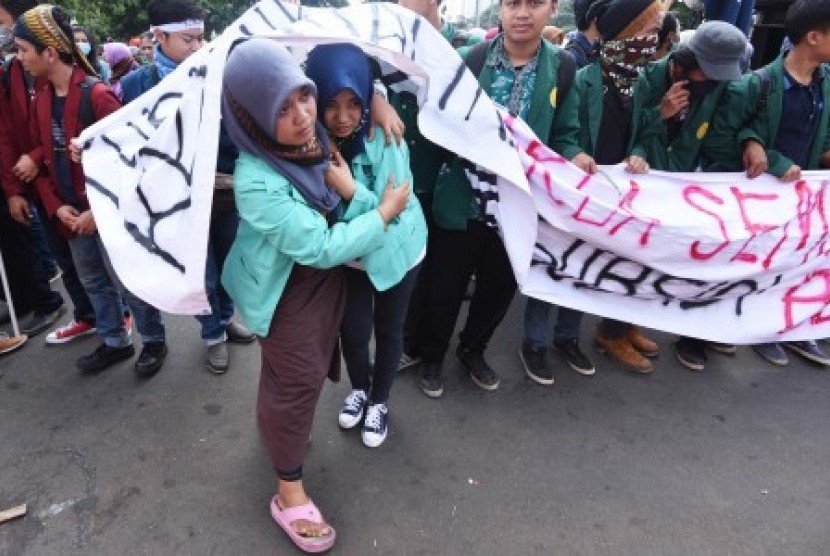 Seorang mahasiswa mengevakuasi temannya yang sakit saat berlangsungnya aksi demonstrasi memperingati Hari Kebangkitan Nasional (Harkitnas) di depan Istana Merdeka, Jakarta, Kamis (21/5). Aksi yang diikuti ribuan mahasiswa berbagai daerah itu sekaligus meny