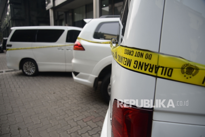 Seorang melintas disamping mobil sitaan milik bos First Travel yang merupakan tersangka untuk kasus penipuan dan penggelapan,pencucian uang serta pelanggaran Undang-undang Informasi dan trasnsaksi Elektronik (ITE), di halaman Bareskrim Polri, Jakarta, Senin (14/8). 