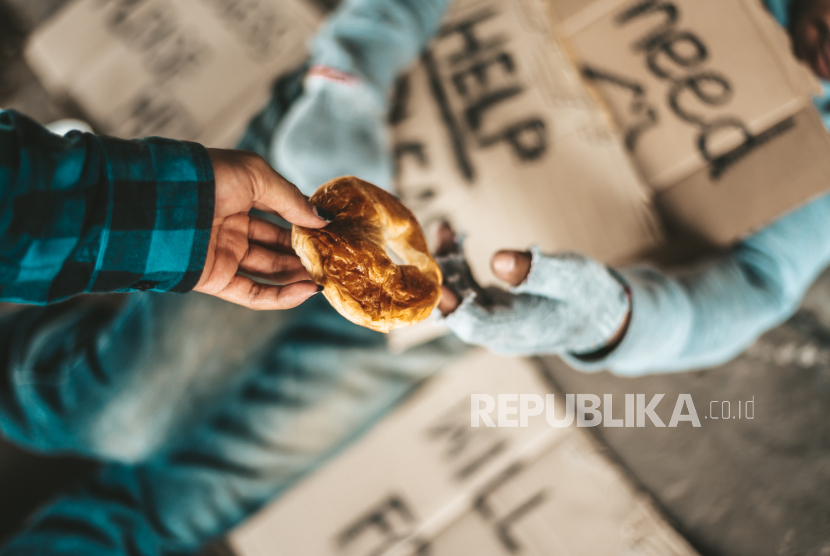 Seorang memberi roti kepada pengemis (ilustrasi). Indonesia masuk urutan ke-21 paling dermawan.