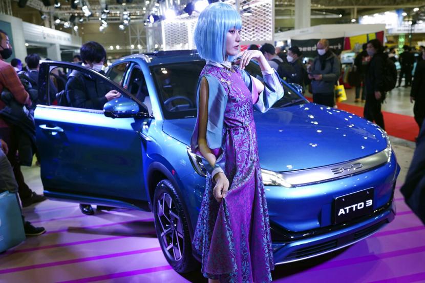 Seorang model berpose di dekat kendaraan listrik ATTO 3, salah satu mobil terbaru dari produsen mobil China BYD di Tokyo Auto Salon, sebuah acara industri yang mirip dengan pameran otomotif dunia, Jumat, 13 Januari 2023, di Chiba dekat Tokyo. 