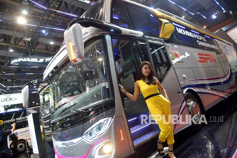 Seorang model berpose di samping bus yang dipamerkan di pameran kendaraan komersial, Gaikindo Indonesia International Commercial Vehicle Expo (GIICOMVEC) di Jakarta Convention Center, Jakarta Pusat, Kamis (5/3/2020).