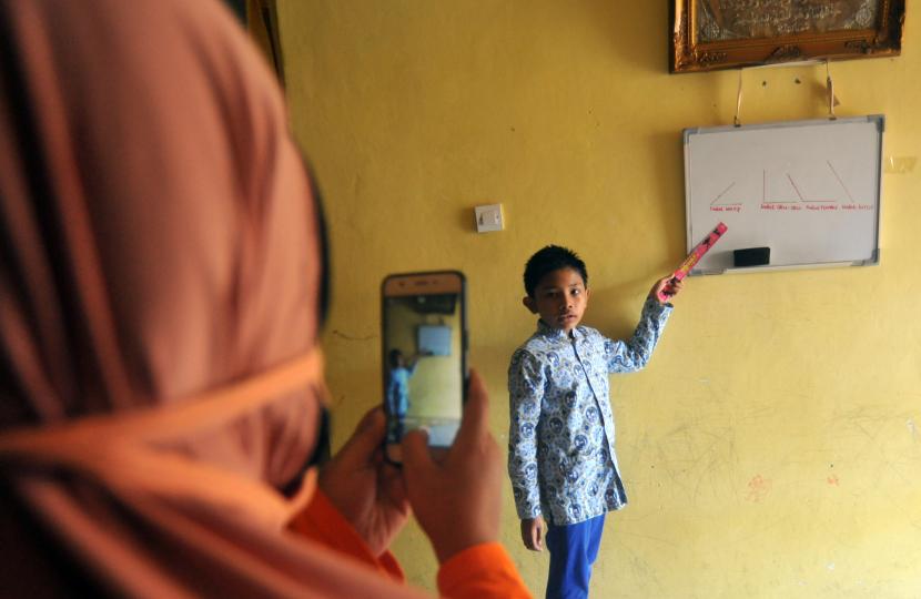 Seorang murid SD membuat video belajar Matematika dari rumah untuk sekolah, di Desa Rawang, Pariaman, Sumatera Barat, Selasa (21/7/2020). Pemkot Pariaman kembali menutup seluruh sekolah dan meniadakan belajar tatap muka pasca ditemukannya guru di daerah itu yang positif COVID-19.