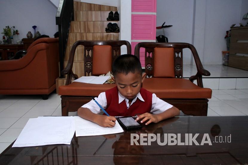 Seorang murid sekolah dasar mengerjakan soal Ujian Akhir Semester (UAS) Genap di rumahnya (Ilustrasi). Persatuan Guru Republik Indonesia (PGRI) meminta agar tidak ada pelajar yang tidak naik kelas. 
