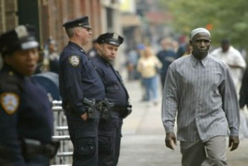 Seorang Muslim berjalan melintas di depan petugas polisi kota New York (NYPD) yang sedang bertugas. Pria Kulit Hitam Kembali Dibunuh, Muslim Amerika Serukan Reformasi Sistemik Kepolisian