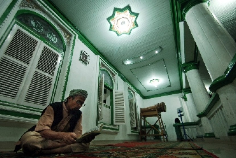 Seorang Muslim tengah membaca Alquran di masjid.