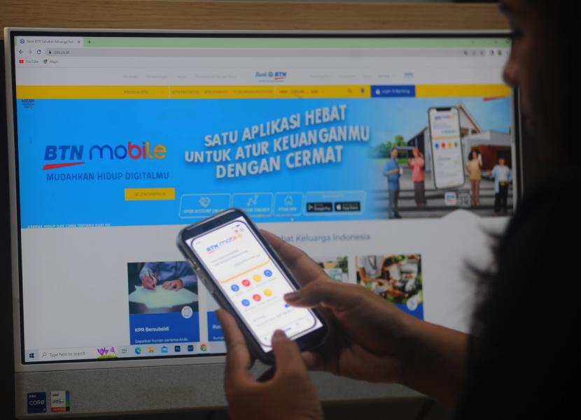 Seorang nasabah bertransaksi menggunakan aplikasi BTN Mobile di Jakarta, Jumat (5/5/2023).