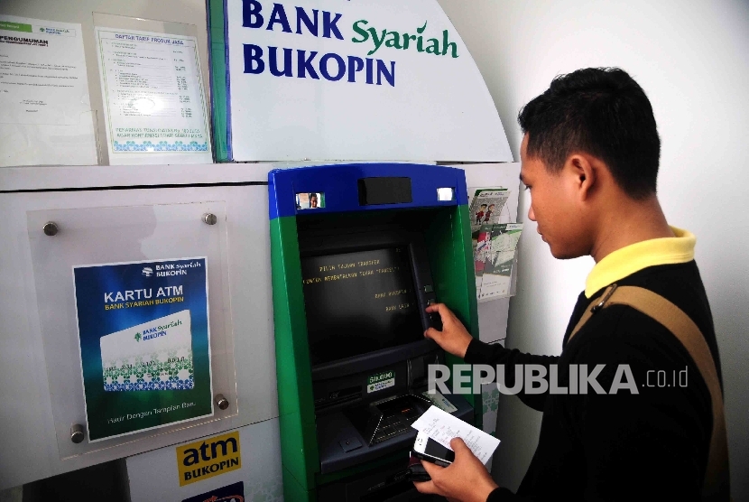 Seorang nasabah melakukan transaksi menggunakan mesin ATM Bank Bukopin Syariah, Jakarta, Ahad (17/4). (Republika/Agung Supriyanto)