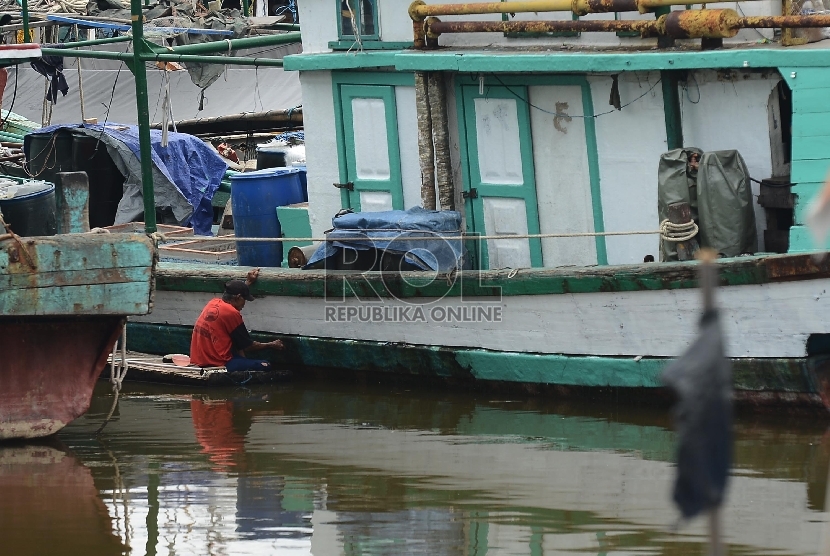 Seorang nelayan memperbaiki kapalnya di Pelabuhan Muara Angke, Jakarta Utara, Selasa(7/4).  (Republika/Raisan Al Farisi)