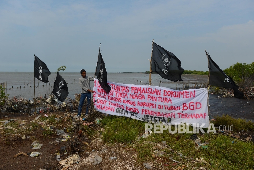  Seorang nelayan merapikan spanduk berisi penolakan pengerukan pasir di perairan Serang, Banten, Rabu (27/4). (Republika/Raisan Al Farisi)