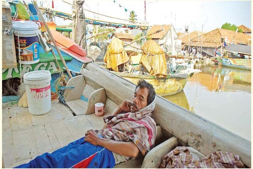 Seorang nelayan terlelap di kapalnya yang berlabuh di pantai utara daerah Eretan, Indramayu, Jawa Barat, Selasa (26/8).Akibat langka BBM jenis solar di jalur pantai utara,para nelayan tidak melaut.