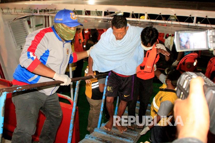 Seorang nelayan yang berhasil selamat dari kapal tenggelam dievakuasi dari atas kapal Basarnas saat tiba di Pelabuhan Tenau Kupang, NTT, Ahad (5/7/2020). Sebanyak 28 warga yang terdiri dari 12 orang nelayan dan 16 orang penumpang dari Kupang menjadi korban kecelakaan kapal di tengah laut yang tenggelam akibat cuaca buruk. Dari 28 warga itu, enam orang masih dalam pencarian, dua orang ditemukan meninggal dan sisanya selamat.