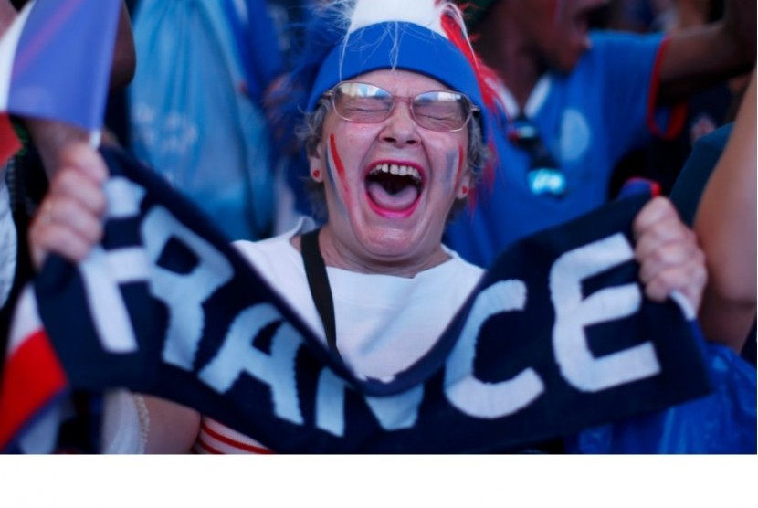 Seorang nenek pendukung Prancis bersemangat merayakan gol tim kesayangannya di fan zone Kota Nice.