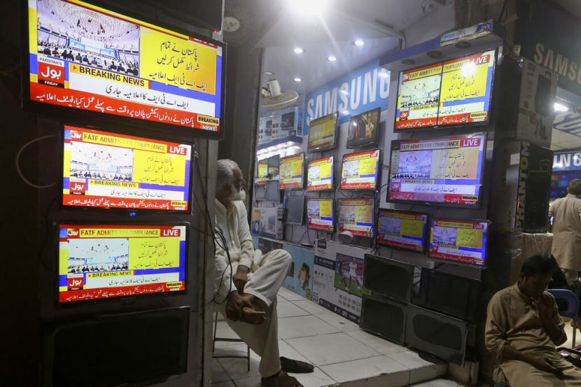 Seorang Pakistan menonton saluran berita yang menayangkan berita tentang keputusan FATF, di sebuah pasar di Karachi, Pakistan, Jumat, 17 Juni 2022. China telah menyetujui pinjaman dana sebesar 2,3 miliar dolar AS untuk Pakistan.