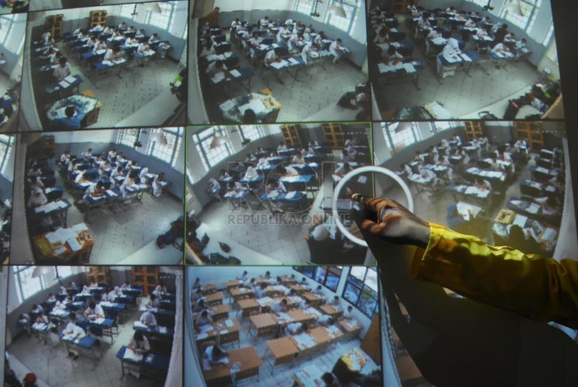 Seorang paniatia pengewas independen memantau Ujian nasional (UN) dengan menggunakan CCTV di ruangan panitia SMAN 1 Jakarta, Jakarta Pusat, Senin (14/4). 