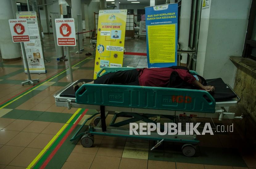 Seorang pasien beristirahat sambil menunggu ruangan rawat inap di ruang Instalasi Gawat Darurat Rumah Sakit Dokter Hasan Sadikin (RSHS), Bandung, Jawa Barat, Sabtu (12/6/2021) malam.