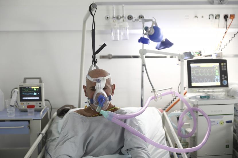 Seorang pasien bernapas melalui masker oksigen 